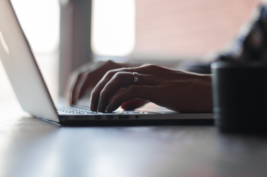 banner image of hands typing on laptop